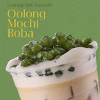 Oolong milk tea with oolong mochi boba on a green background